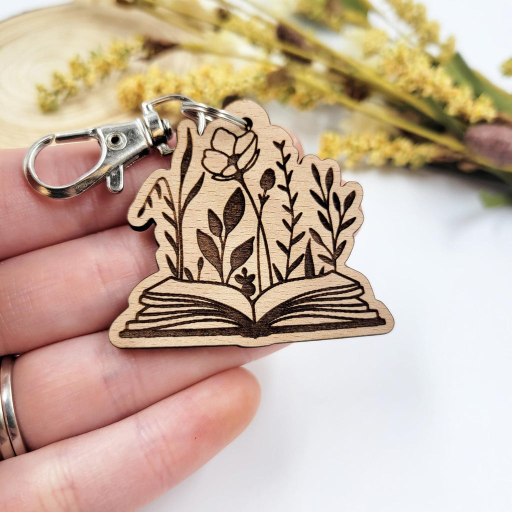 Flowers emerging from an open book engraved wooden keychain