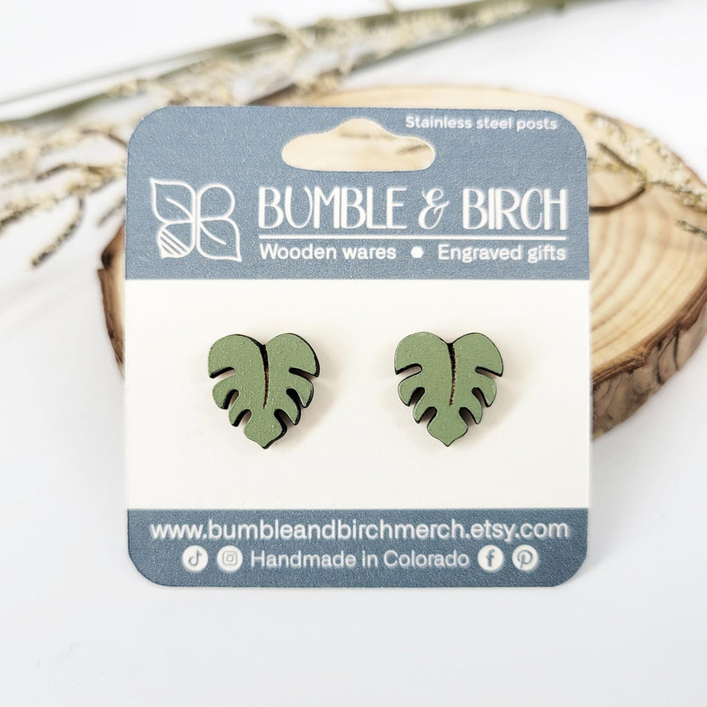 Green monstera leaf shaped stud earrings with packaging