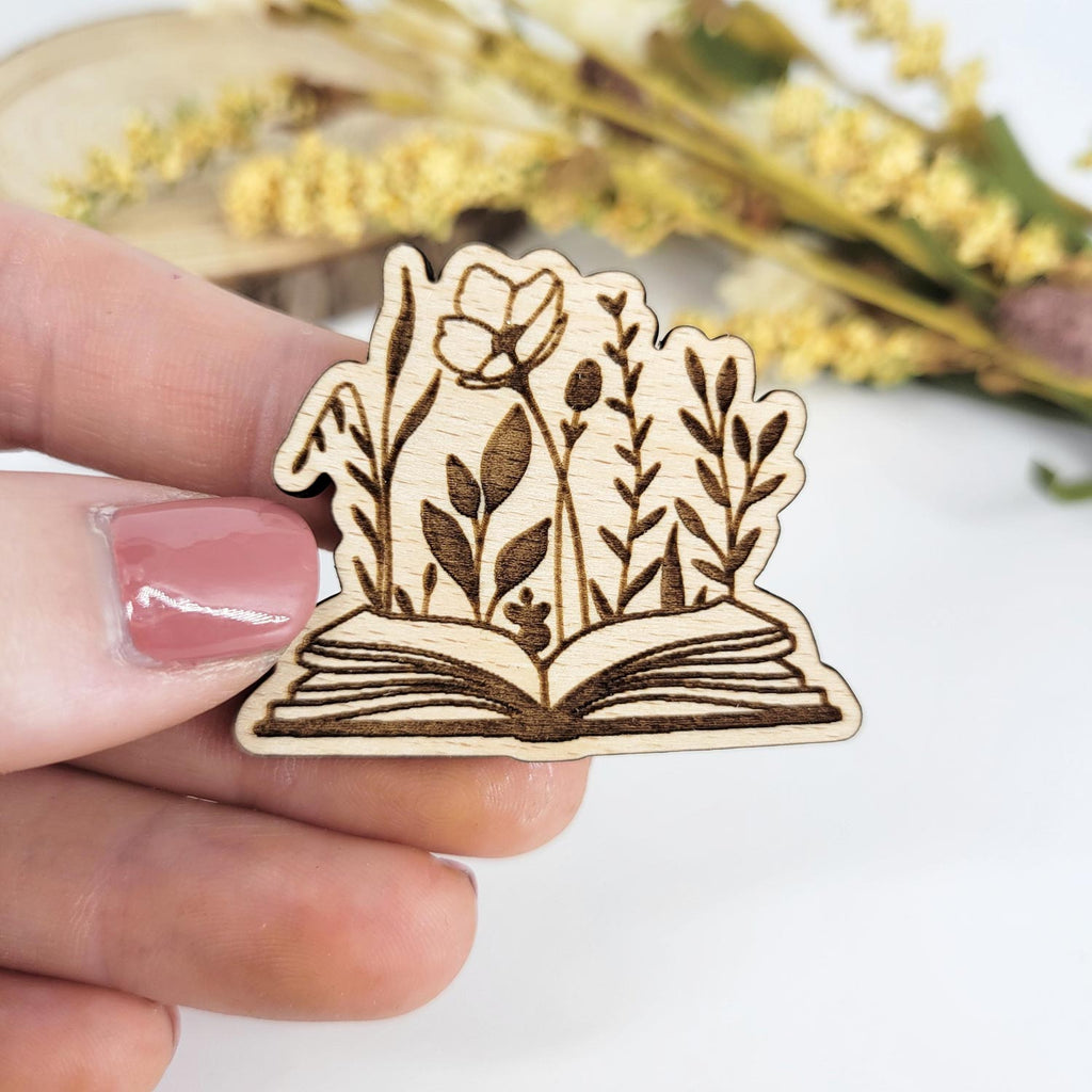 Flowers emerging from an open book engraved wooden pin