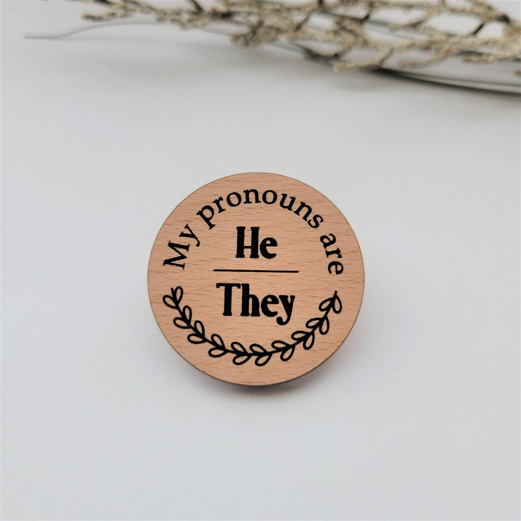 My pronouns are He/They wood round pin