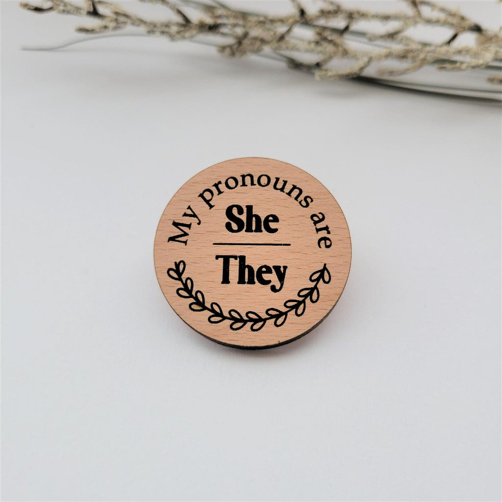 My pronouns are She/They wood round pin
